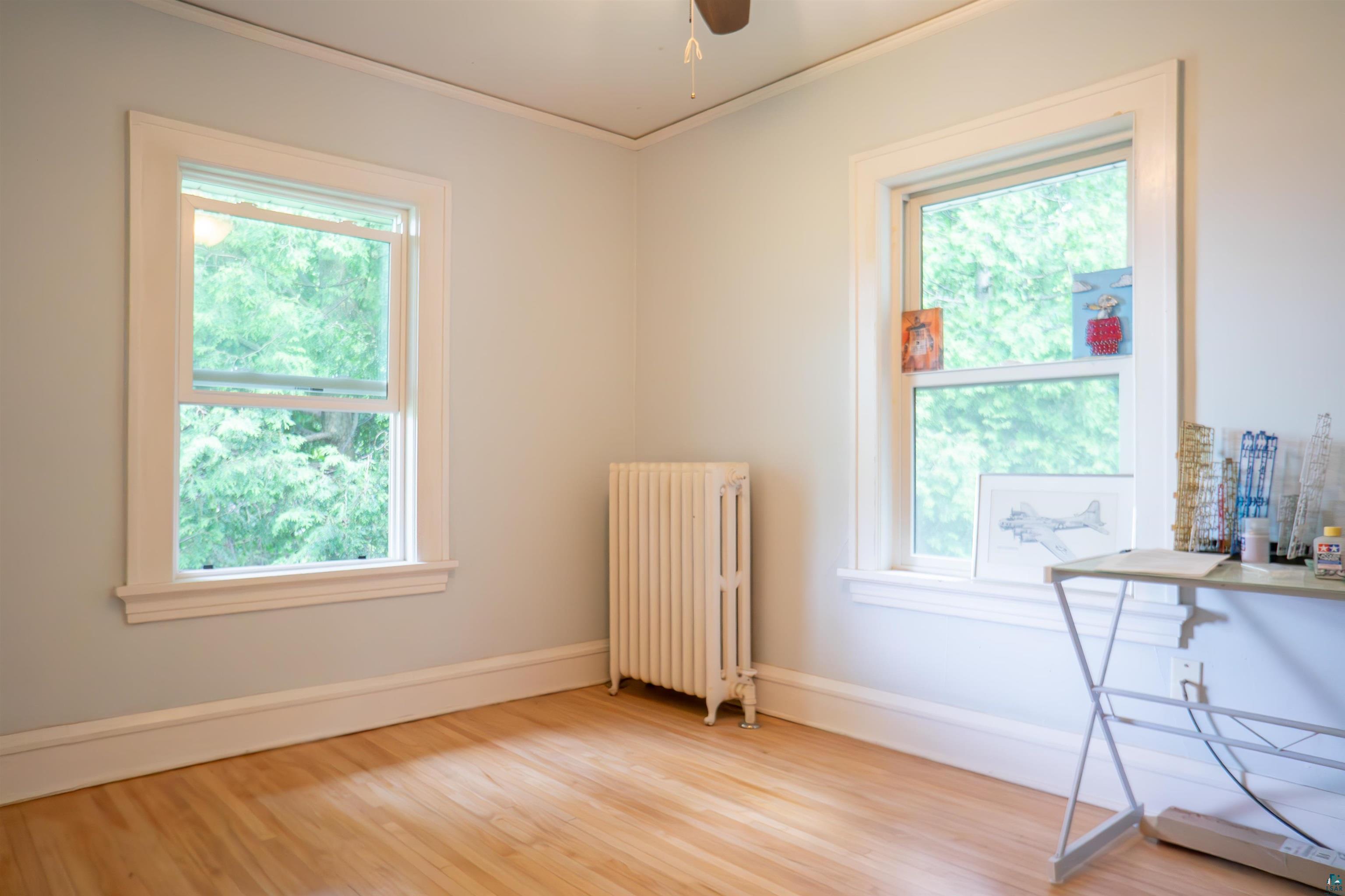 201 Snively Road Duluth, MN 55803 - Photo 16 of 21 Interior space with plenty of natural light, radiator heating unit, ceiling fan, and light hardwood / wood-style flooring