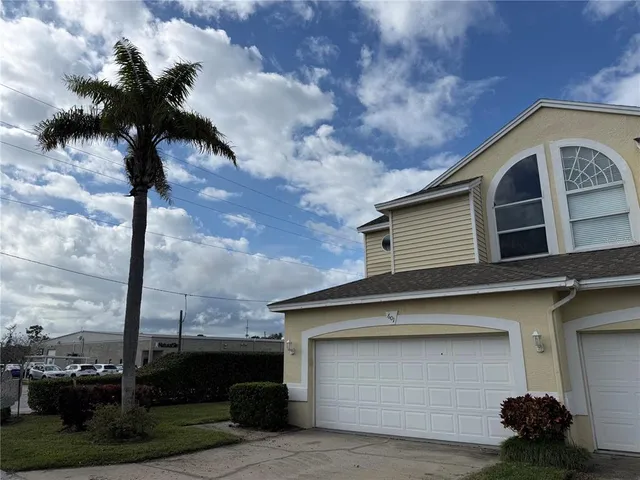a front view of a house with a garden and trees