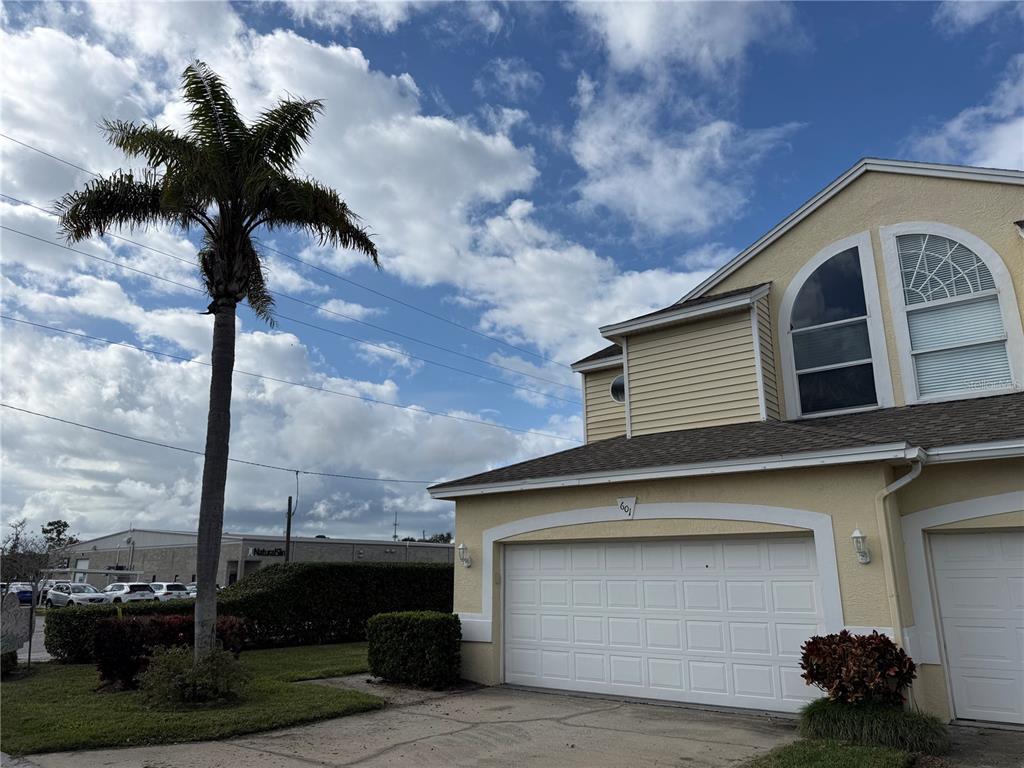a front view of a house with a garden and trees