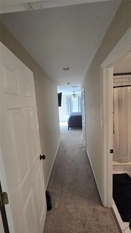 a view of a hallway to rooms and stairs