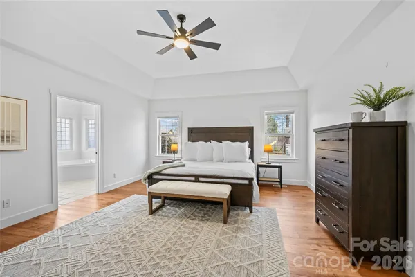 a spacious bedroom with a bed and a chandelier