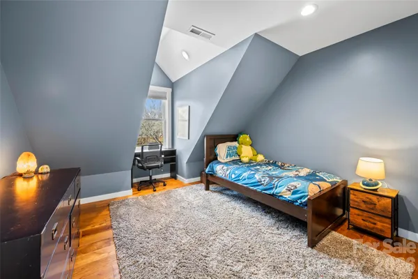 a bedroom with furniture and a wooden floor