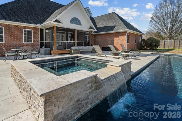a view of a house with pool and chairs