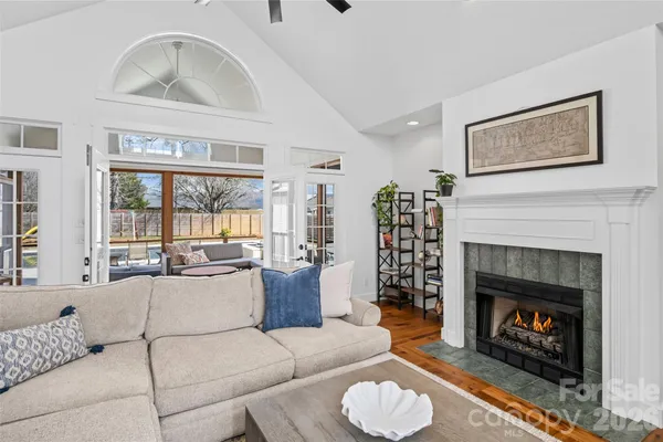 a living room with furniture a fireplace and a large window