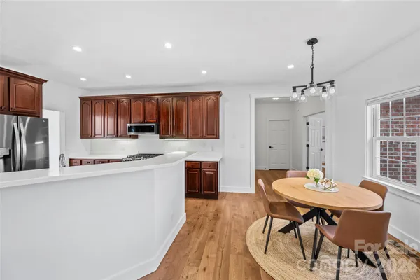 a kitchen with kitchen island a dining table and chairs