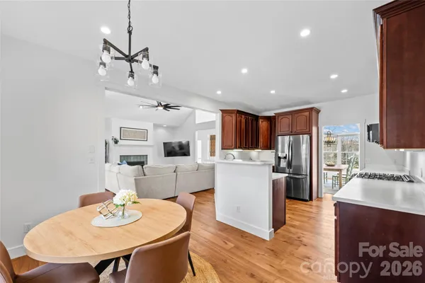 a view of a dining room and livingroom with furniture wooden floor a chandelier