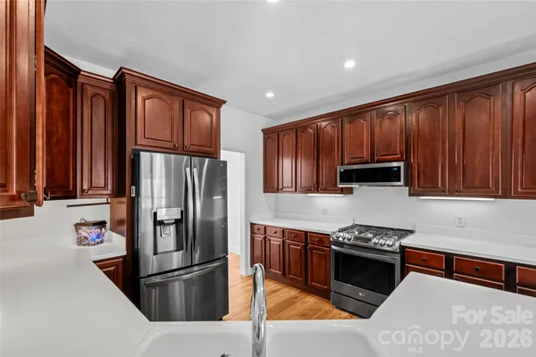 a kitchen with stainless steel appliances granite countertop a refrigerator stove and oven