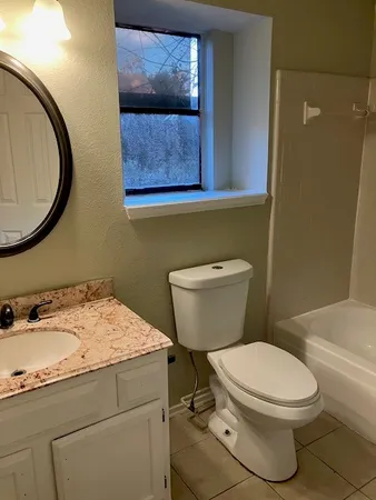 a bathroom with a toilet a sink and mirror