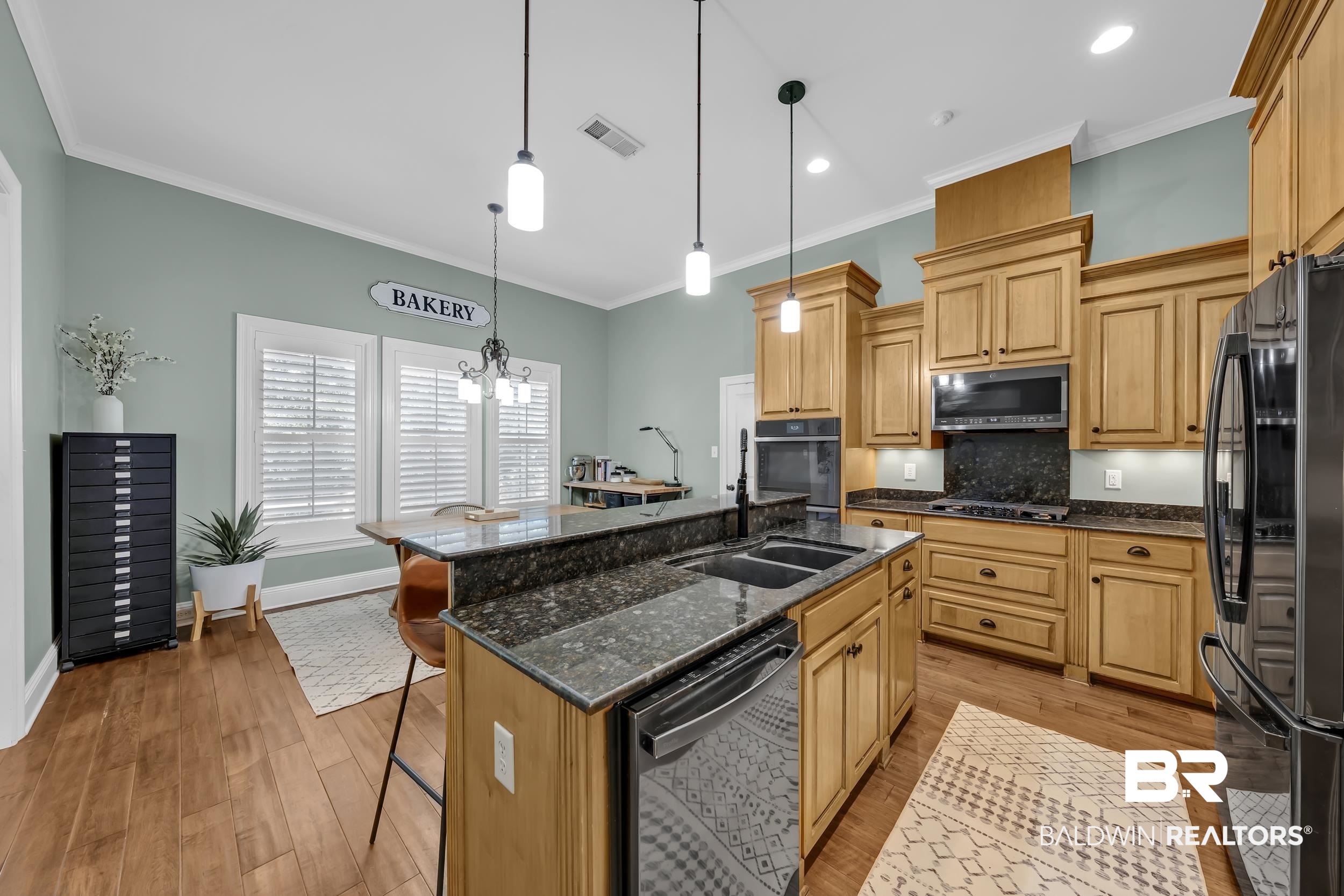 8137 Pine Run Daphne, AL 36527 - Photo 19 of 67 Kitchen featuring wood-finish flooring, light wood cabinetry, and dark stone countertops