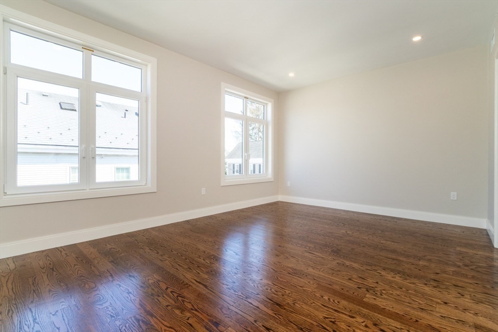15 Tanglewood Road, Unit A Boston, MA 02126 - Photo 15 of 28 a view of an empty room with wooden floor and a window