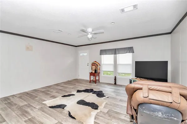 a kitchen with kitchen island a stove a refrigerator and a view of living room