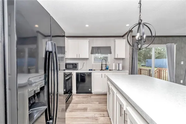 a kitchen with a stove a sink a microwave and cabinets