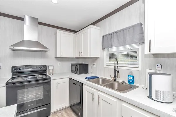a kitchen with stainless steel appliances granite countertop white cabinets and a stove