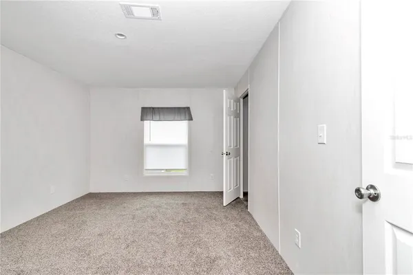 a spacious bedroom with a bed and a window