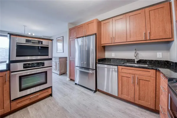 a kitchen with granite countertop a refrigerator stove and microwave