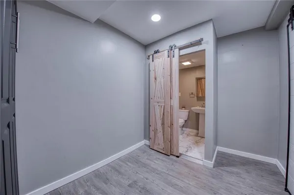 an empty room with wooden floor and a bathroom