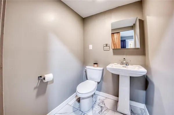 a bathroom with a sink toilet and a mirror