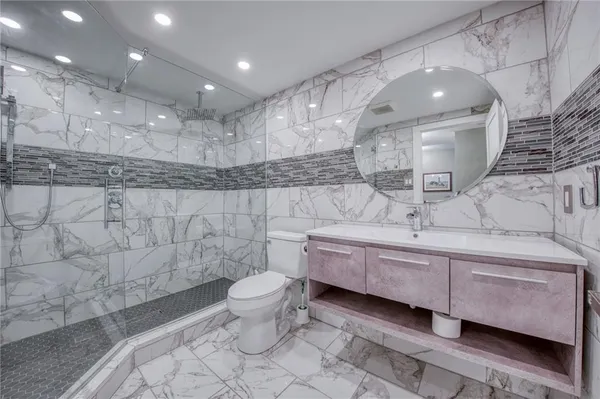 a bathroom with a double vanity sink a toilet and a mirror