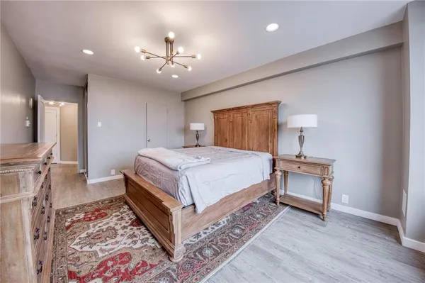 a bedroom with a bed and a chandelier