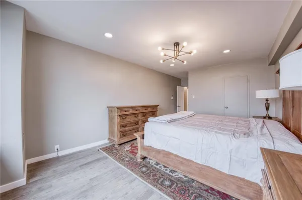 a spacious bedroom with a bed and a chandelier