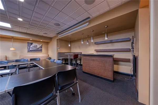 a dining hall with stainless steel appliances granite countertop a sink a stove and a wooden floors