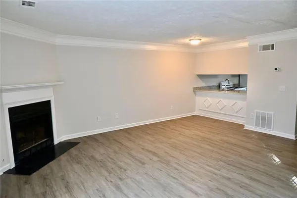 a view of a room with wooden floor and a fireplace