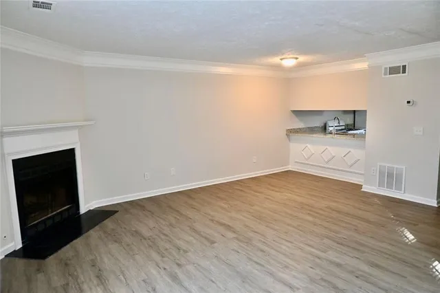 a view of a room with wooden floor and a fireplace