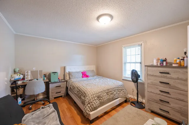 a bedroom with a bed and wooden floor