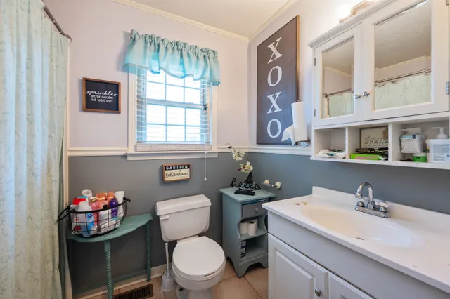 a bathroom with a toilet sink and mirror