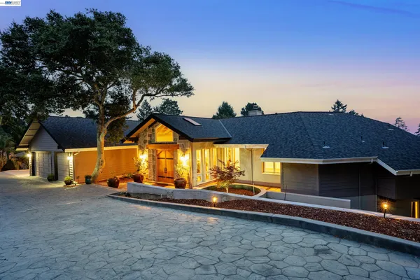 an aerial view of residential house with outdoor space and trees all around