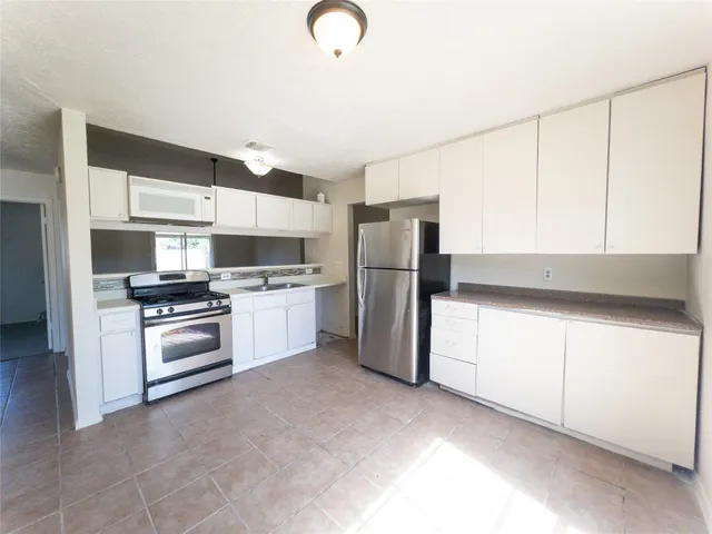 a kitchen with stainless steel appliances a refrigerator sink and stove