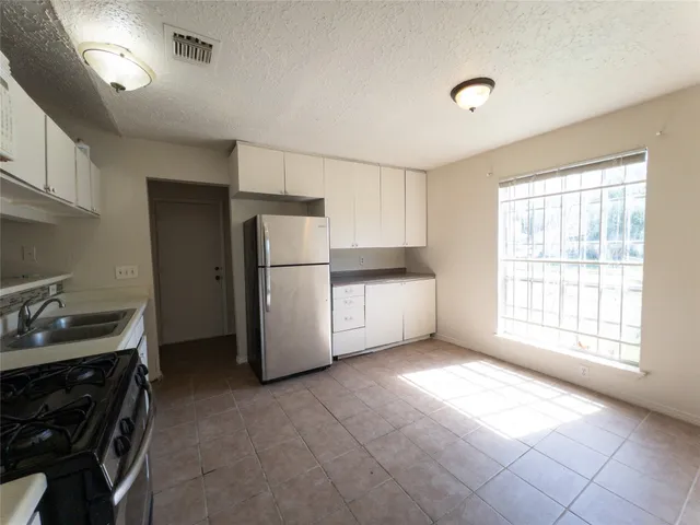 a kitchen with a refrigerator and a stove top oven