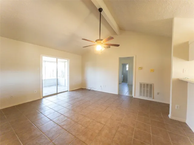 a view of a livingroom with a chandelier fan and windows
