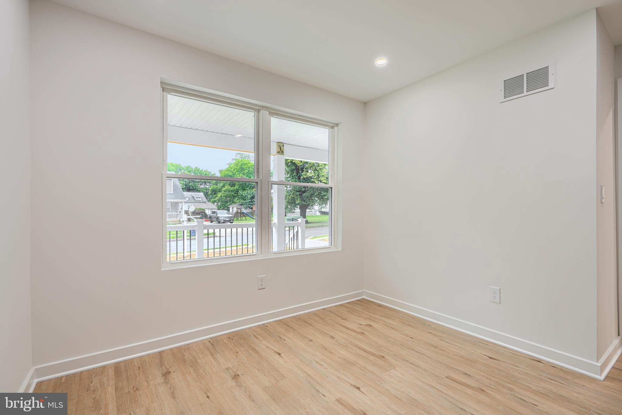 3410 Pinkney Road Baltimore, MD 21215 - Photo 17 of 55 an empty room with wooden floor and windows