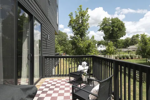a balcony with wooden floor and outdoor seating