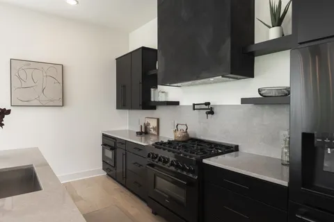 a kitchen with stainless steel appliances a stove a sink and a microwave