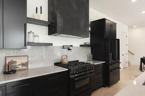 a kitchen with stainless steel appliances granite countertop a refrigerator and a stove