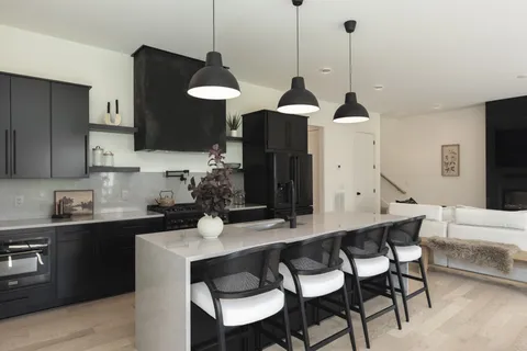 a kitchen with a dining table chairs and a wooden floor