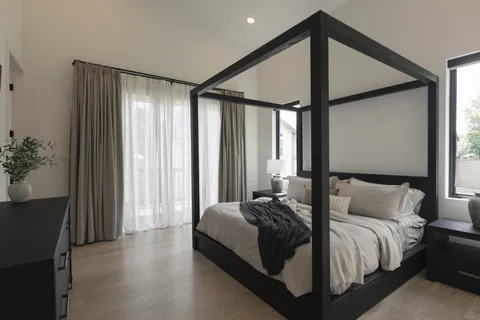 a bedroom with a large bed and a chandelier