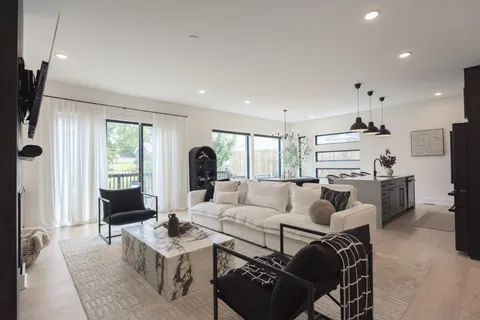 a living room with furniture a large window and a chandelier
