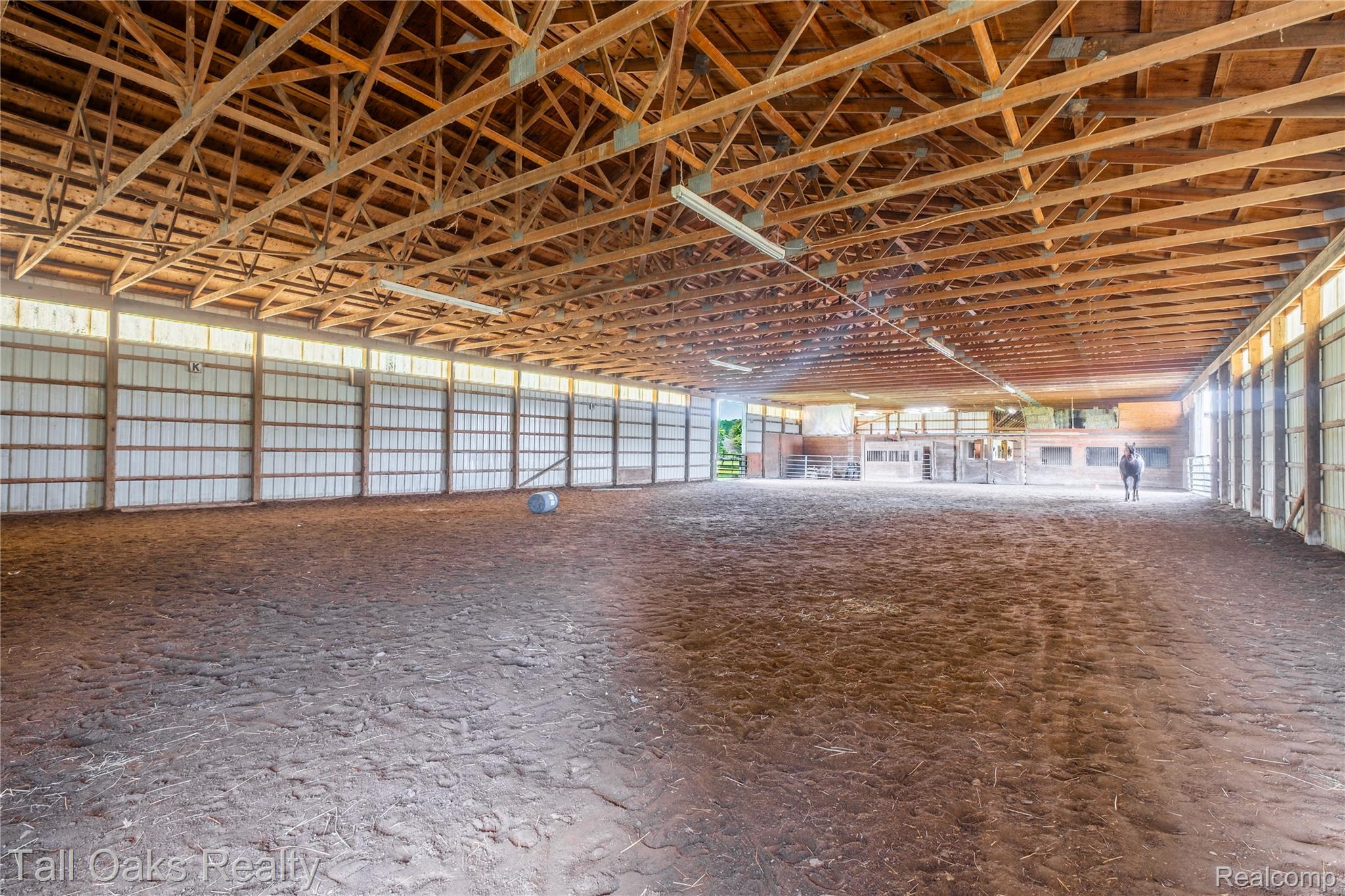 79330 Capac Road Armada, MI 48005 - Photo 9 of 42 Spacious indoor arena featuring an open-truss wood ceiling and expansive earthen flooring