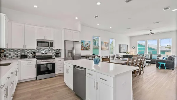 a large kitchen with sink a counter space stainless steel appliances and cabinets