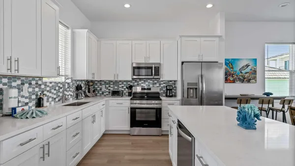 a kitchen with white cabinets and stainless steel appliances