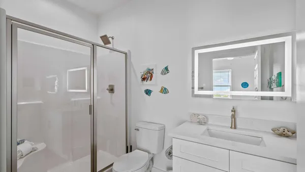 a bathroom with a sink toilet vanity and shower