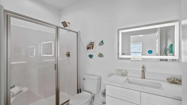 a bathroom with a sink toilet vanity and shower