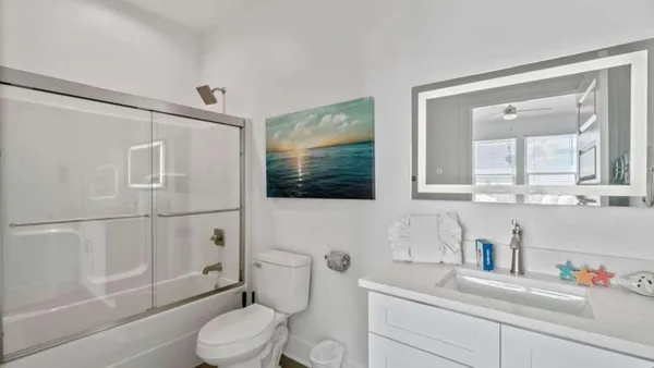 a bathroom with a sink a toilet and shower