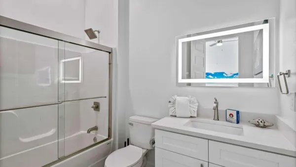 a bathroom with a granite countertop sink mirror vanity and toilet
