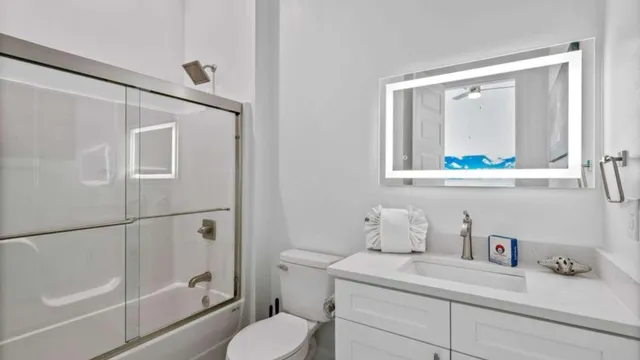 a bathroom with a granite countertop sink mirror vanity and toilet