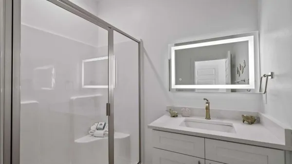 a bathroom with a granite countertop sink and a mirror