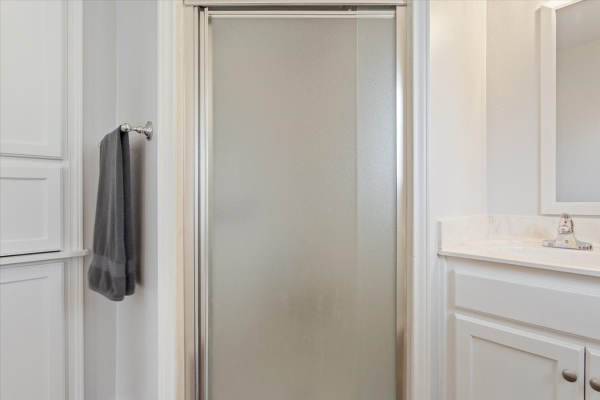 1607 North Harding Avenue Cameron, TX 76520 - Photo 21 of 37 A streamlined shower enclosure and clean vanity define this functional bathroom space.
